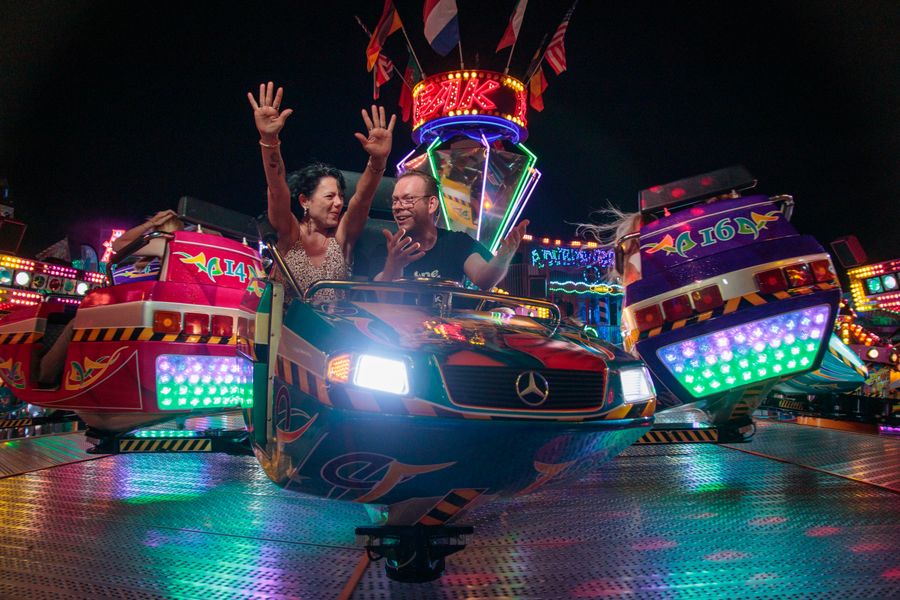 Pareja disfrutando parque de diversiones nocturno